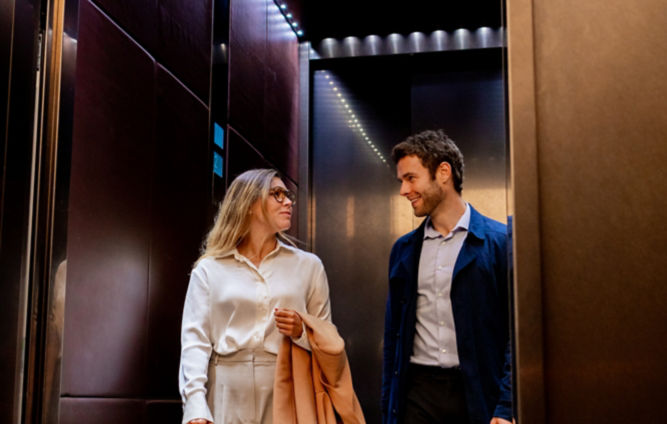 Hombre y mujer de negocios saliendo de un elevador